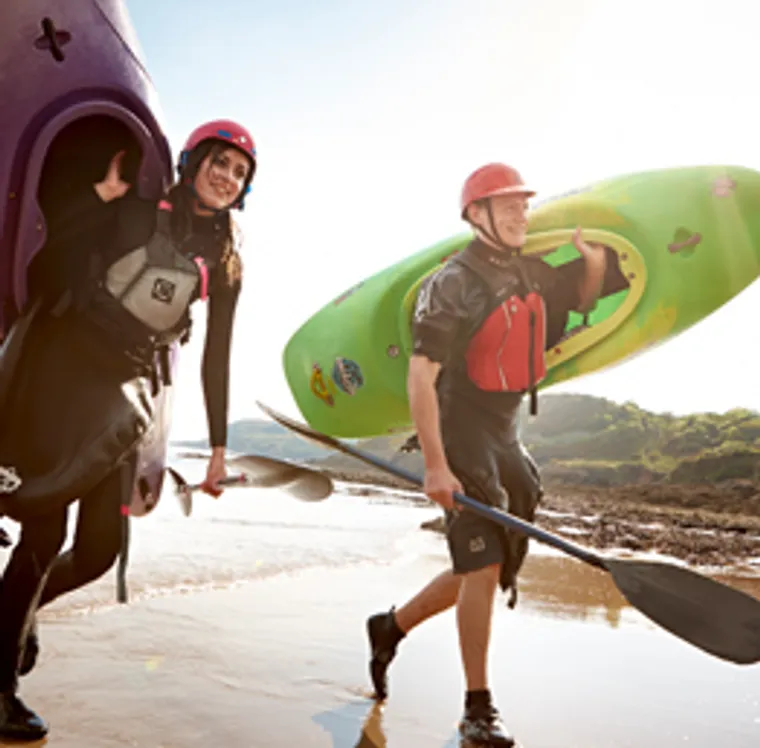 Students on the beach with canoes